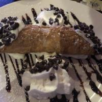 Cannoli · A crispy pastry shell filled with creamy ricotta and chocolate chips dusted with powdered su...