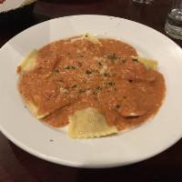 Lobster Ravioli · Lobster ravioli topped with tomato cream sauce and Parmesan cheese. 