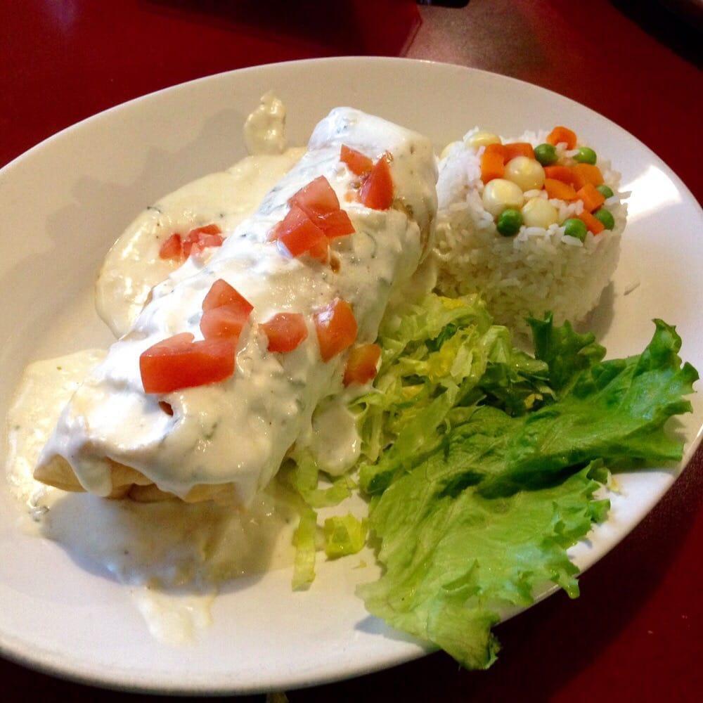 Seafood Chimichanga · Large flour tortilla filled with crab salad, shrimp and jack cheese, deep-fried, then topped with sour cream sauce and tomatoes. Served with rice and salad.