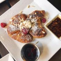 Almond Croissant · Home-baked stuffed croissants, honey ricotta whip, raspberries and almond butter syrup.