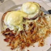 Eggs Benedict · 2 poached eggs on an English muffin with Canadian bacon and hollandaise. Served with hash br...