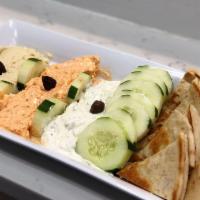 3 Dip Appetizer · Red, white and beige dip sauce. Spicy feta, tzatziki and hummus with cucumbers and pita.