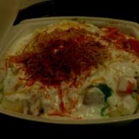 Samosa Chat · Samosa topped with garbanzo, tomatoes, onions and crispy sev yogurt. Served with mint and co...