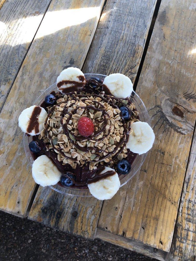 Berry Bliss Bowl · Acai berry, blueberries, raspberries, blackberries, bananas, local date puree and almond milk. Topped with our house-made gluten-free granola, bananas, blueberries and house-made dark chocolate drizzle.*

**dark chocolate drizzle contains almonds**