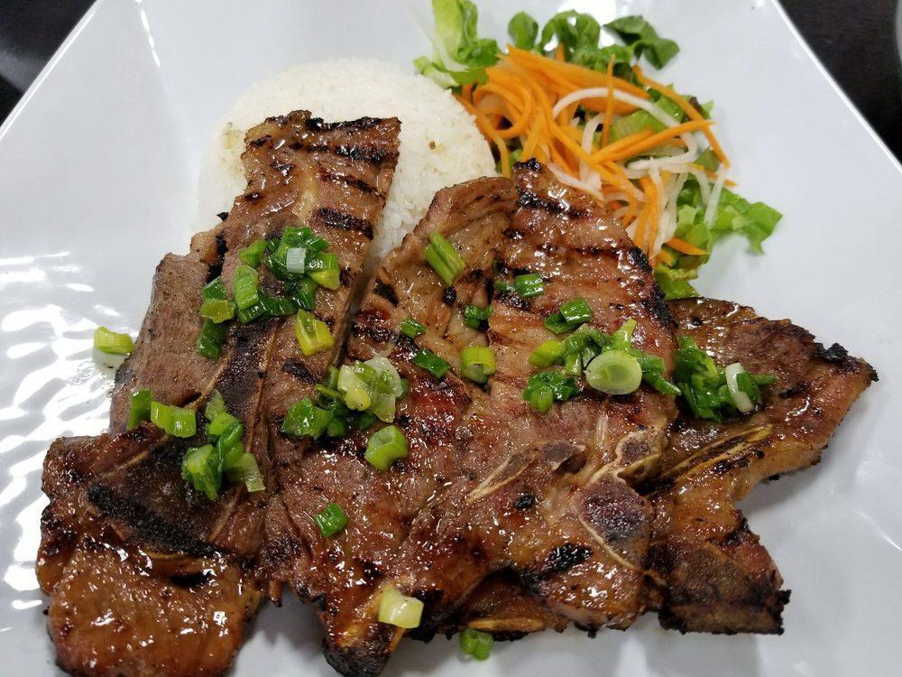 Pork Chops Over Rice · Seasoned and grilled pork chops over rice and a salad, a traditional Vietnamese dish.