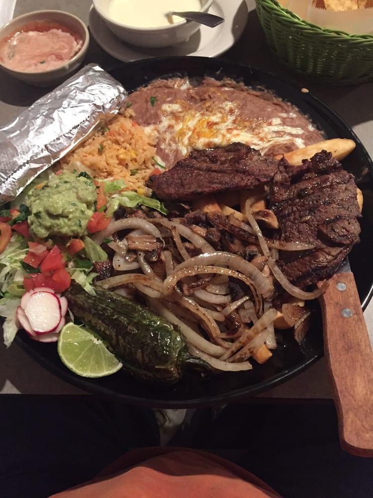Carne Asada · Steak cooked to perfection, topped with grilled onions, mushrooms, french fries and seasoned grilled jalapeños served with guacamole, lettuce and pico de gallo, rice and beans.