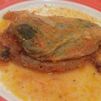 Chile Rellenos · 2 poblano peppers stuffed with cheese battered and crisp fried, topped with a mild seasoned ...