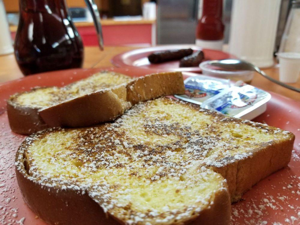 French Toast · 2 challah slices topped with powdered sugar, served with brown sugar butter and warm syrup.