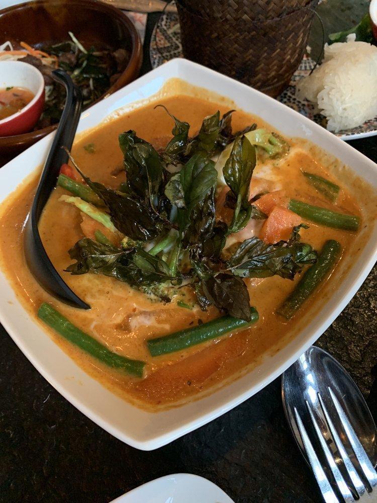 Panang Crispy Duck Curry · Mildly spiced. Crispy roasted duck in panang curry sauce, red bell, carrot, broccoli, and fried thai holy basil. Topped with fresh coconut cream. Served with jasmine rice.