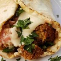 Taco Falafel Sandwich · Crunchy falafel on soft warm tortilla served with spicy tahini paste, cabbage and tomato sal...