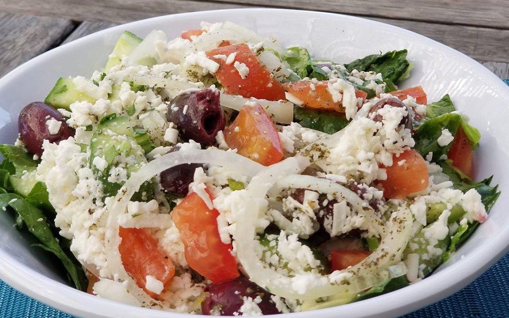 Greek Salad · Romaine lettuce, tomatoes, fresh chopped mint, chopped parsley, cucumber, feta cheese, olives, fresh lemon juice, and organic extra virgin olive oil, topped with fresh onions. Add chicken kabob, shawarma for an additional charge. Vegetarian.