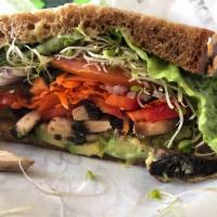 Farmer's Market Sandwich · A garden sandwich on 9-grain bread piled high with avocado, sunflower seeds, sliced pickles,...