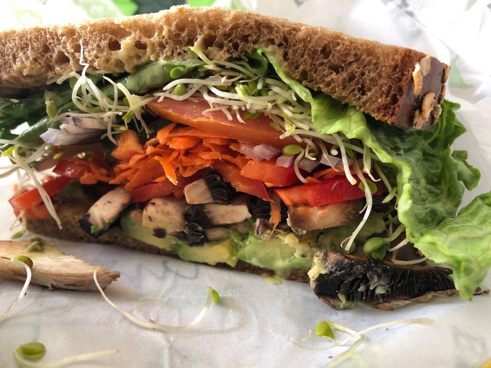 Farmer's Market Sandwich · A garden sandwich on 9-grain bread piled high with avocado, sunflower seeds, sliced pickles, mushrooms, grated carrots, red bell pepper, onions, tomato, clover sprouts, lettuce, and Erik's sweet hot mustard.