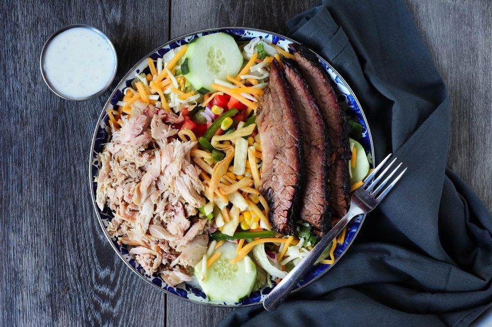 Smokehouse Salad · Smoked turkey, Texas brisket, cheddar & jack cheeses, roasted corn relish, cucumbers, red onions, tomatoes, on seasonal greens.