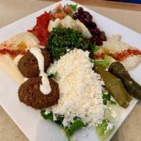 Mediterranean Combo Platter · A mixed platter with hummus, baba ghanouj, dolma, tabbouli, falafel, feta cheese, artichokes...
