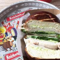Turkey Sandwich · Oven roasted turkey breast on pretzel roll with avocado, cucumber, arugula and basil aioli.