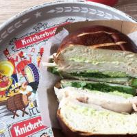 Turkey Sandwich · Oven roasted turkey breast on pretzel roll with avocado, cucumber, arugula and basil aioli.