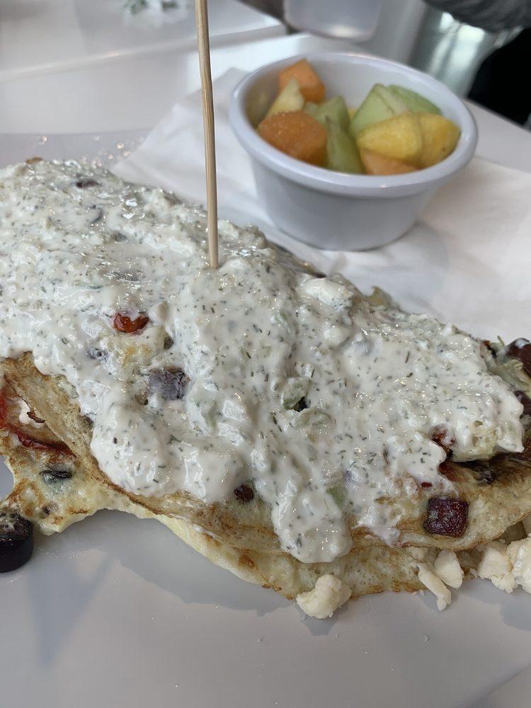 Greek Omelet · Egg whites, roasted tomatoes, Kalamata olives, red onion, feta cheese, topped with a Greek yogurt tzatziki sauce. Served with a side of fruit.