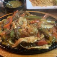 Ultimate Fajitas · Chicken, shrimp, and steak with bell peppers served on a sizzling skillet with sides of sour...