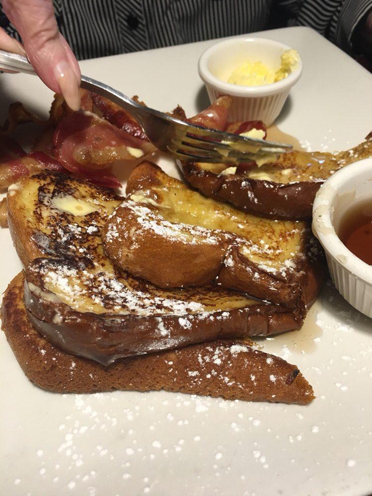 French Toast · Challah bread dipped in vanilla egg batter. Butter, syrup, and sprinkled with powdered sugar.