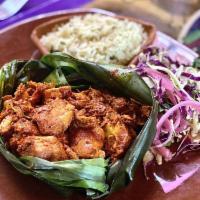 Cochinita Pibil · Slow-roasted pork cooked in banana leaf, Yucatan-style, pickled red onion, black beans, and ...