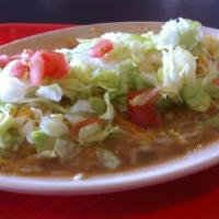 Smothered Tamale Plate Smothered with Pork Green Chili, Cheese, Lettuce Tomatoes and Onions · 