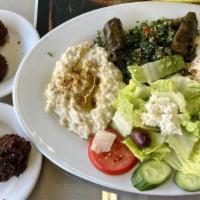 Veggie Combo Plate · Hummus, tabbouleh, babaganouj, Greek salad, tahini sauce, pita bread with two falafel balls ...