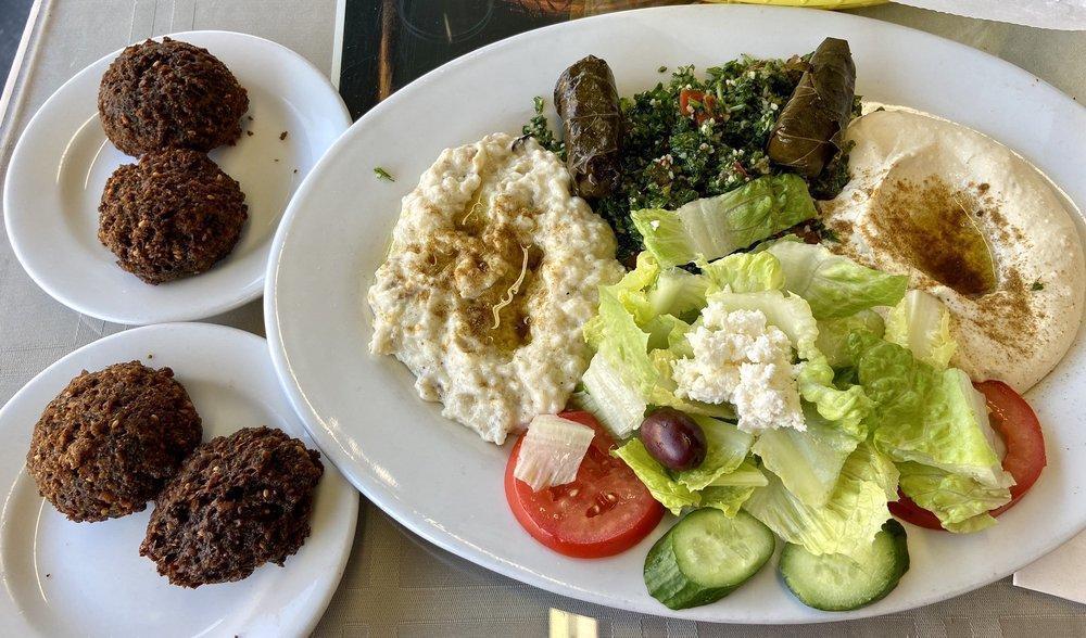 Veggie Combo Plate · Hummus, tabbouleh, babaganouj, Greek salad, tahini sauce, pita bread with two falafel balls and dolmas.