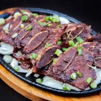 Kalbi · Korean short ribs marinated in house sauce. Comes with rice and 4 small sides.