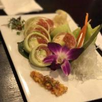 Paradise Roll · Tuna, salmon, yellowtail, crab, spicy tuna, avocado, masago and wrapped in cucumber and driz...