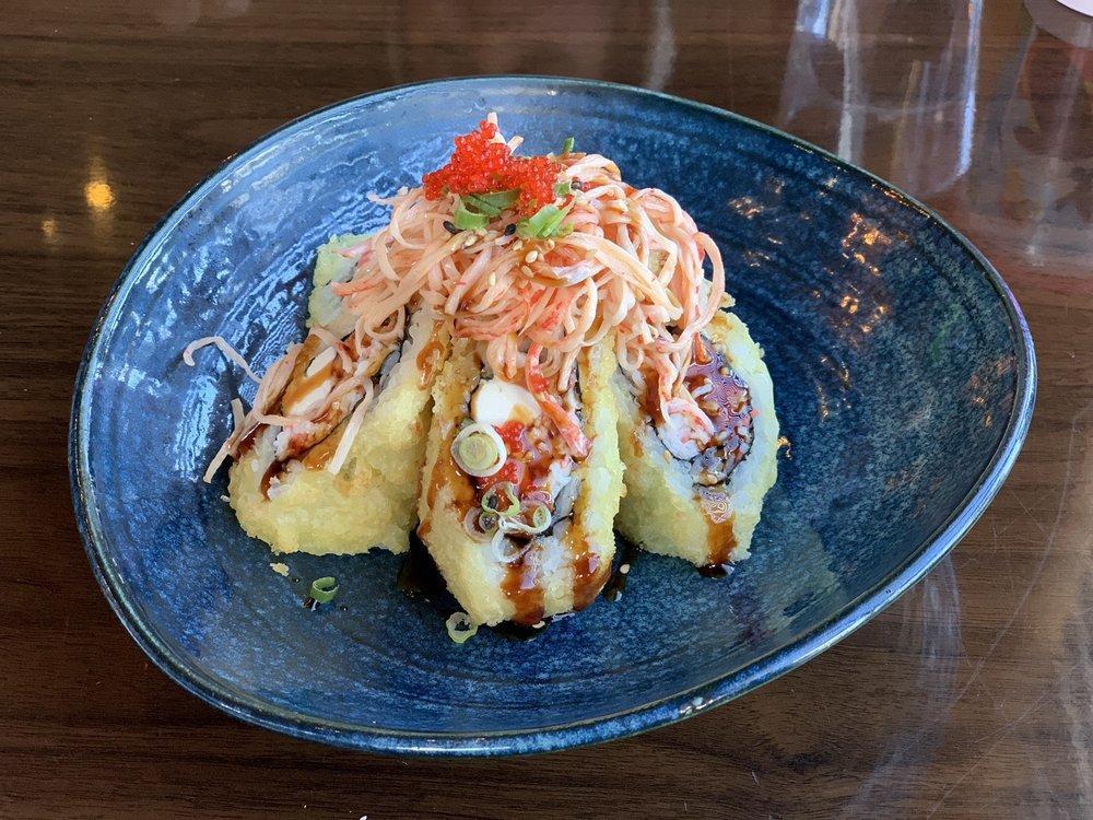 Volcano Roll · Deep fried roll with spicy crab, cream cheese, topped with spicy crab salad, masago, scallions and crunch, unagi sauce.