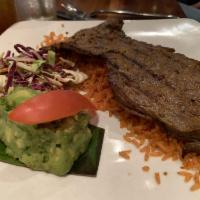 Carne Asada · Traditional grilled Mexican cut of steak served with rice, charro beans, and garnished with ...