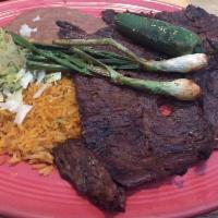 Carne Asada · Tender slices of grilled steak served with guacamole, onions and deep fried jalapeno garnish...
