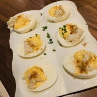Crabby Eggs · Deviled eggs with crab meat, old bay, lemon and chives.
