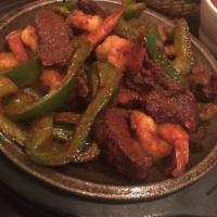 Steak Fajitas · pan tossed with onion, tomato, red and green pepper. served with rice, beans, guacamole, cre...