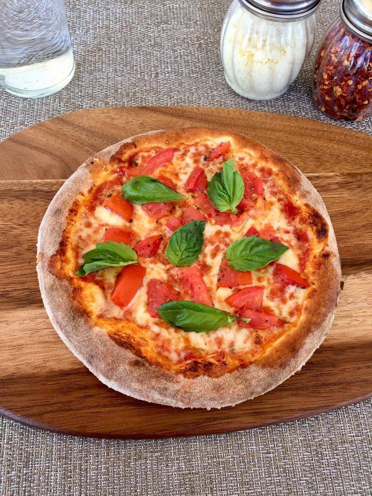 Margherita Pizza · Mozzarella, tomato sauce, tomatoes, fresh basil, olive oil. Vegetarian.