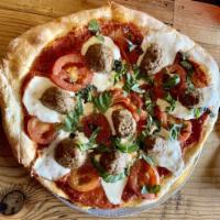 Margherita Pizza · Red sauce, fresh mozzarella, Roma tomatoes, and garnished with fresh basil.