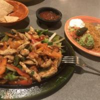 Chicken Fajitas · Tender pieces of marinated chicken sauteed with bell peppers, onions and tomatoes. Garnished...