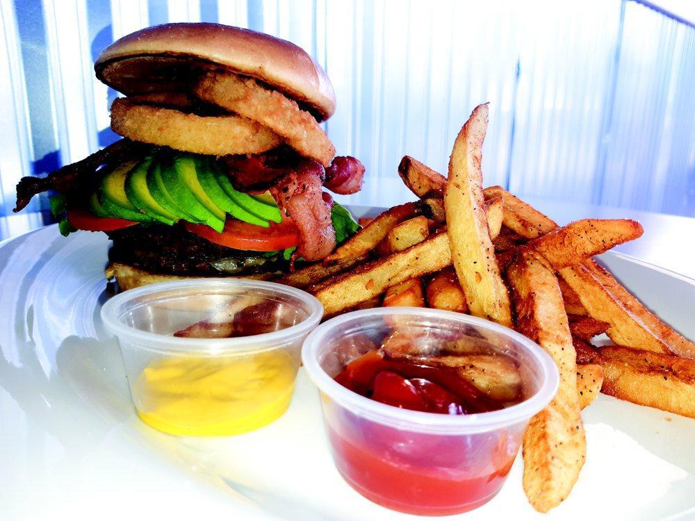 Hungry Lion Burger · Served with 2 meat patties, pickles, lettuce, tomato, avocado, two onion rings, bacon, cheddar and Swiss cheese.