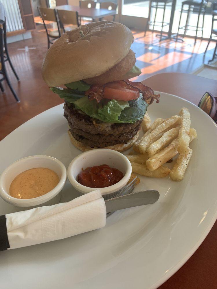 Hungry Lion King Burger · Served with 3 meat patties, pickles, lettuce, tomato, avocado, two onion rings, bacon, cheddar and Swiss cheese.