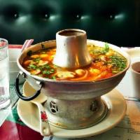 Tom Yum · Signature hot and sour soup made with spices and herbs. Tomato, mushroom, and onion, topped ...