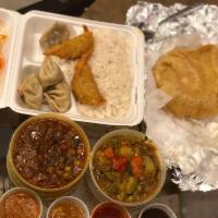 Vegan Thali · Vegan feast including mismas takari, puri bread, 5 vegetable momos, 2 samosas, steamed rice ...