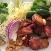 Sri Siam Spicy Ribs · Fried spicy pickled pork spareribs served with cabbage, cilantro, jalapeno, ginger, red onio...