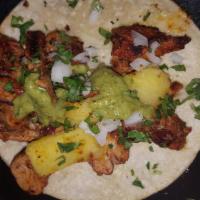Al Pastor Taco · Marinated slow-cooked pork topped with fresh onion, cilantro and pineapple.