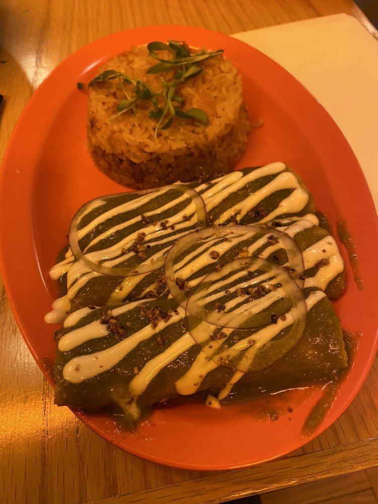Enchiladas Mole · Shredded palm carnitas, coconut queso, guajillo pepper, sour cream, served with Spanish rice. Spicy. Contains nuts.