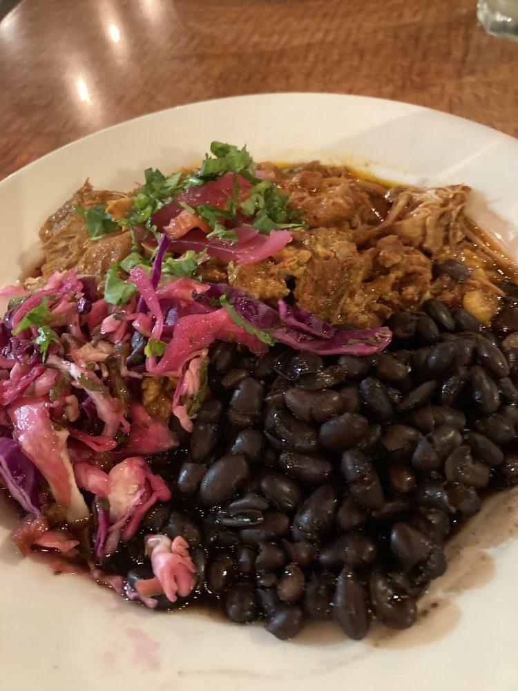 Cochinita Pibil · Slow roasted, citrus, and achiote marinated pork shoulder, habanero pickled onion and black beans