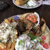 Chicken Gyro · Greek chicken gyro slices with melted mozzarella cheese on pita bread with tomato, onion & h...