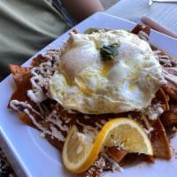 Chilaquiles · Traditional Mexican. Tortilla chips sauteed in a red sauce topped with 2 eggs, sour cream, q...
