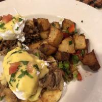 Cochon Eggs Benedict · Slow braised pork on a biscuit with 2 soft poached eggs, hollandaise and served with home fr...