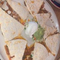 Quesadilla · 2 crispy flour tortillas stuffed with cheddar and Jack cheese, green onions and tomatoes. Se...